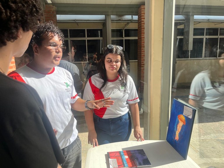 3 estudantes apresentando obras.jpg